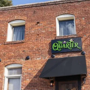 a brick building with a sign that says quarter