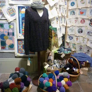 Sweater display, part of the yarn selection and cross stitch patterns at The Quarter Stitch