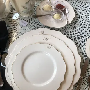 Place setting with scone spreads-- herb butter, almond Devonshire cream and strawberry preserves.