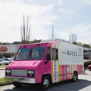 a pink food truck parked in a parking lot