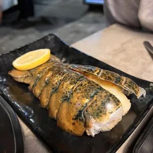 grilled fish with lemon wedges
