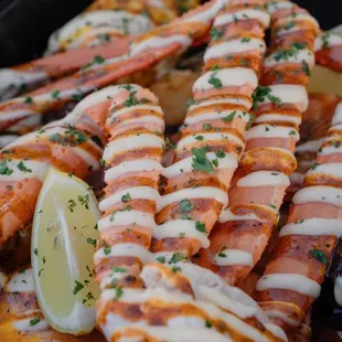 a tray of lobster with a lemon wedge