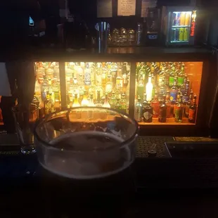 a glass of beer in front of a bar