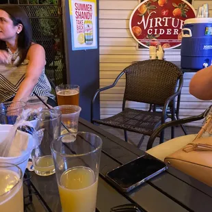 two women sitting at a table with drinks