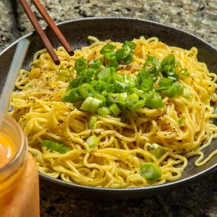 a bowl of ramen noodles with chopsticks