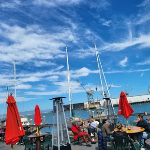 people sitting at tables with red umbrellas