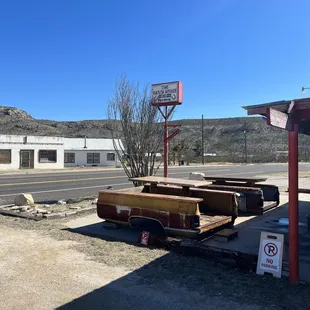 an old car parked in front of a gas station