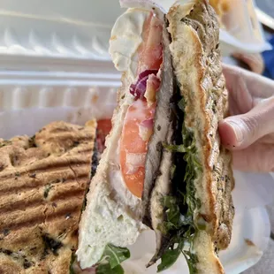 a hand holding a sandwich