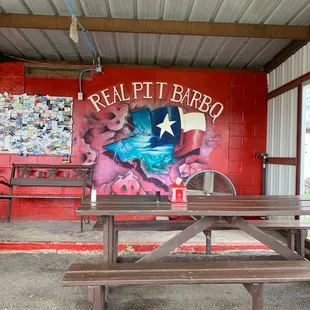 a picnic table in front of a mural