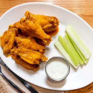 a plate of chicken wings and celery