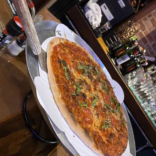 Beef and pepperoni pizza topped with basil