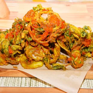 Pakora (Indian Fritters) -- Medley of fresh vegetables sliced thin and then dipped in the restaurant&apos;s signature batter and fried to a golde