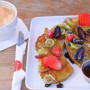 Most delicious French Toast with a lot of fresh fruit. 
 It is made with their home-baked sourdough bread and eggless vegan batter. It comes