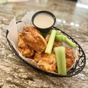 a basket of chicken wings and celery
