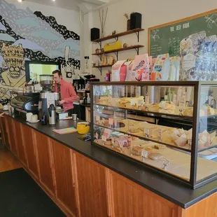 a woman standing in front of a bakery counter