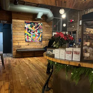 a wooden bar with a large painting on the wall