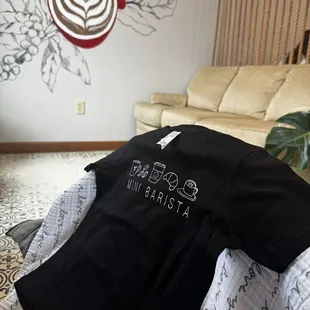 A mini barista tee on top of my baby&apos;s car seat