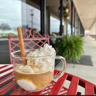 a cup of coffee with whipped cream and a cinnamon stick