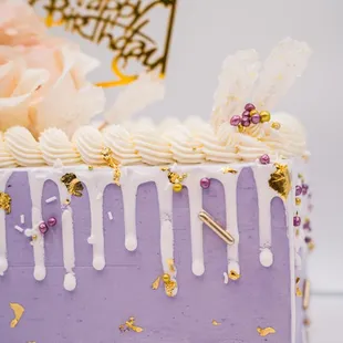a purple cake with white icing and gold decorations