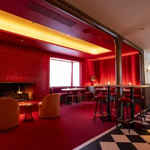 a fireplace and bar with stools