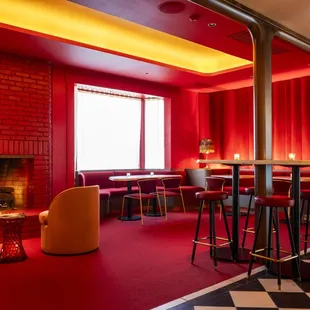 a fireplace and red chairs