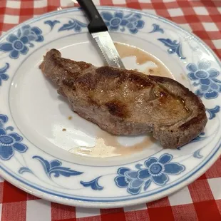 a steak on a plate with a knife