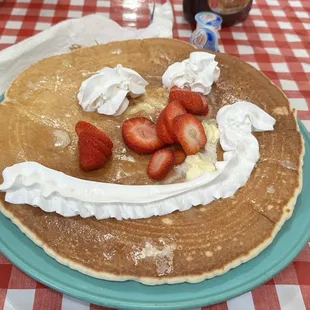 a pancake with strawberries and whipped cream