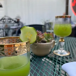 a green drink with a cucumber garnish