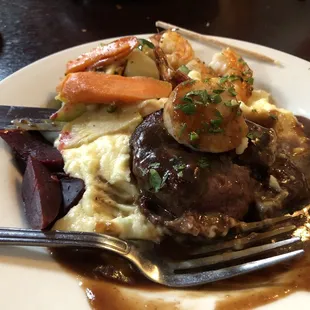 Beef fillet large scallop and three large shrimp with mashed potatoes and fresh vegetables.