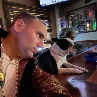 a man sitting at a bar with his dog
