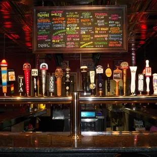 a row of beer taps on a bar