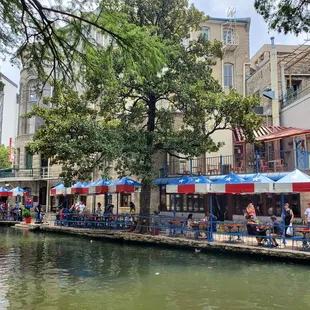a waterway with tables and umbrellas