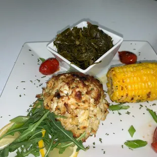 a crab cake, corn and greens