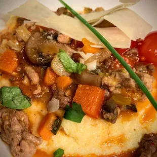 a plate of mashed potatoes with meat and vegetables