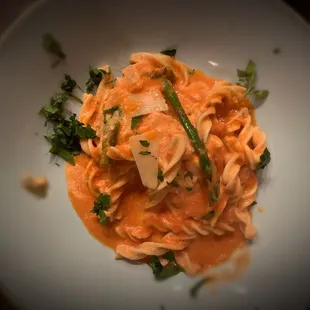 a plate of pasta with sauce and parsley