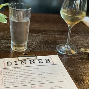 a menu and a glass of wine