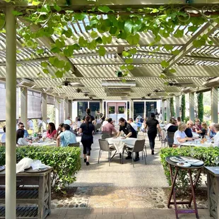 Exterior dining patio with a trellis for shade.