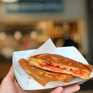 a hand holding a sandwich