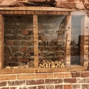 a brick wall with a window and a window pane filled with wine corks