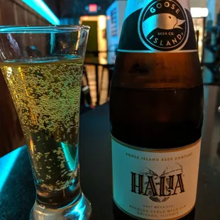 a glass of beer next to a bottle of beer