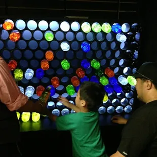 Children work an oversized light box in the Electricians Shop at The Rhelm.