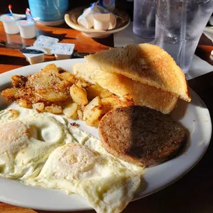 2 eggs, sausage patty, breakfast potatoes, and toast