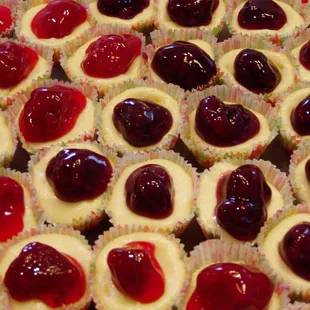 a tray of cupcakes with cherries