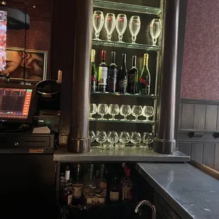 a bar with wine glasses and a sink