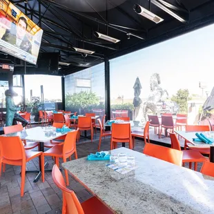 an outdoor dining area with tables and orange chairs