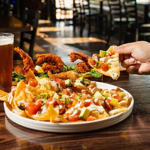 a plate of nachos and a glass of beer