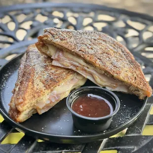 grilled cinnamon french toast pan bread, with smoked ham, turkey, and melted swiss cheese, all sprinkled with powdered sugar and served with