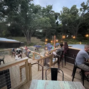 people sitting at tables on the deck