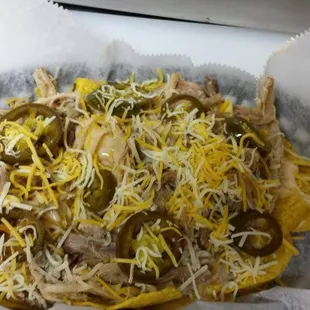 Piggy Nachos - Tortilla Chips toppled with our special nacho cheese, pulled pork, shredded cheese and jalapeno (optional)
