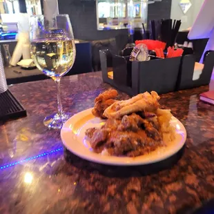 a plate of food and a glass of wine